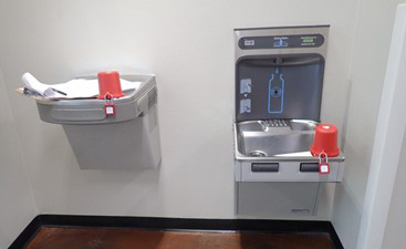 Two water fountains with red cups blocking their use.